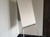 un tableau blanc posé sur un support dans un coin de la pièce
