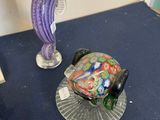 a glass fish sitting on top of a table next to a plate