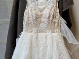 a wedding dress hanging on a hanger in front of a brick wall
