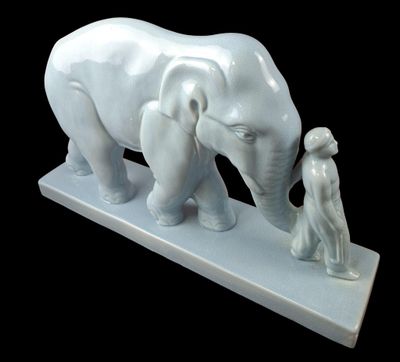 a statue of an elephant and a man standing next to it