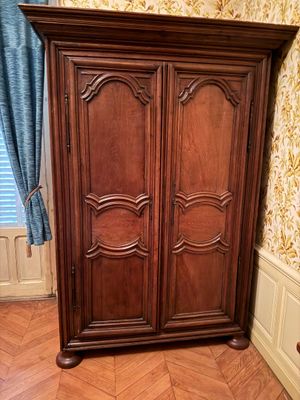 une grande armoire en bois dans le coin d'une pièce