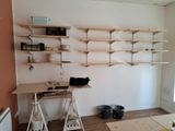 a room with a desk and shelves in it