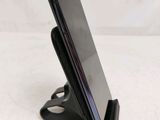 a close up of a cell phone on a stand on a table