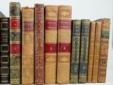 several old books are lined up in a row on a table