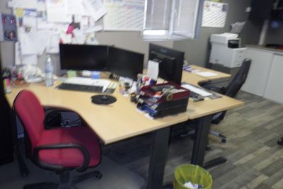 un bureau avec deux ordinateurs et une chaise dans la chambre