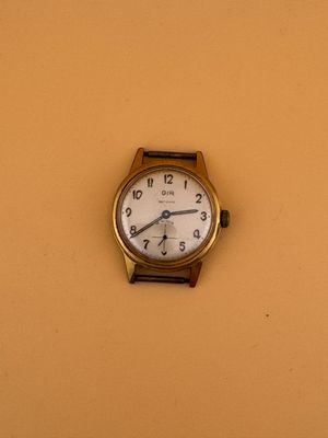 une petite horloge accrochée au mur, dans un coin de la pièce