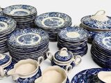blue and white plates and cups and saucers are stacked on top of each other