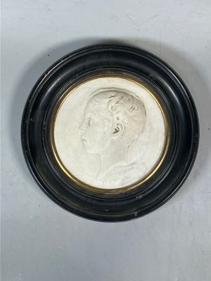 un gros plan d'une pièce de monnaie dans un cadre noir posée sur une surface blanche