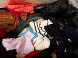 a pile of clothes that is sitting on a bed