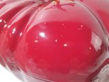 a red pumpkin shaped container with a gold top