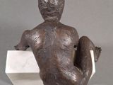 statue of a woman sitting on a block with her legs crossed