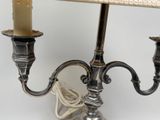 a silver candle holder with two candles on top of it