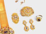 a lot of gold jewelry on a white surface