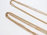 a close up of three gold chains with a gold pendant on them