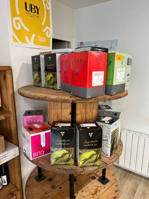 de nombreuses boîtes de thé posées sur un présentoir en bois dans une pièce