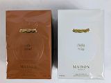 deux boîtes de parfum posées l'une à côté de l'autre sur une surface blanche