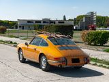 an orange car with a surfboard on top of it