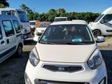 a small white car that is parked in a parking lot
