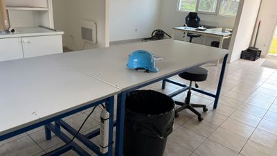 une table sur laquelle est posé un casque bleu, dans une pièce