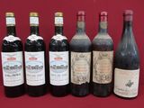 several bottles of wine are lined up on a red cloth