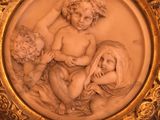 une assiette en or sur laquelle est représentée une femme avec deux enfants