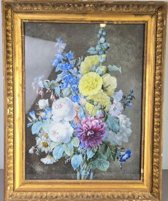 tableau représentant un bouquet de fleurs dans un cadre doré posé sur une table