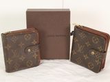 Deux portefeuilles Louis Vuitton sont posés à côté d'une boîte