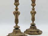 une paire de bougeoirs anciens en laiton sur fond blanc
