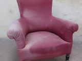 a pink chair that is sitting in front of a wall