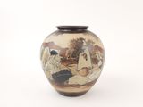 a vase with a painting on it sitting on a table