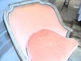 une chaise rose sur laquelle est posé un coussin rose