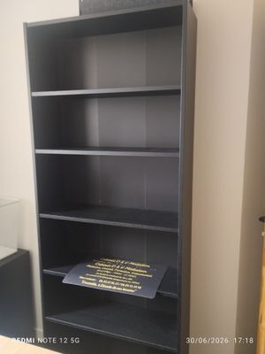 une étagère noire sur laquelle est posé un livre