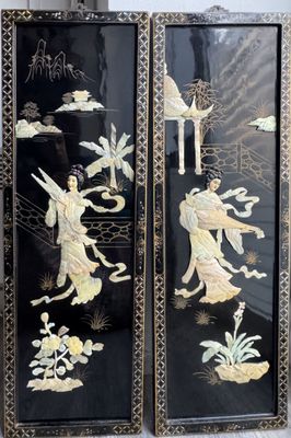 two black and gold paintings on the wall next to each other