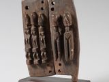 a close up of a sculpture of two people on a wooden base