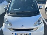 une petite voiture blanche garée dans un parking