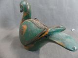 a small green bird that is sitting on a table