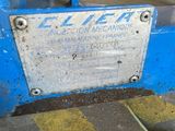 a sign on the side of a blue machine in a garage