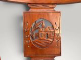 a close up of a wooden table with a carving of a house on it