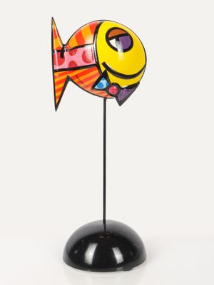 brightly colored fish figurine on a black stand on a white background
