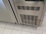 a stainless steel refrigerator with a digital clock on the door