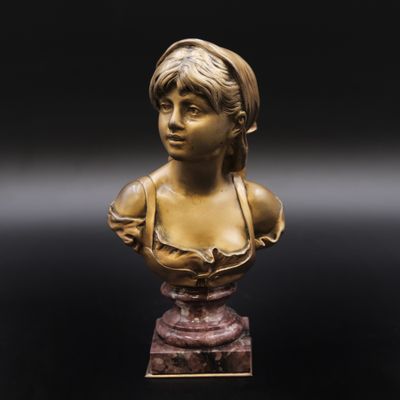 un buste en bronze représentant une jeune fille, posé sur un socle