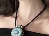une femme qui porte un collier orné d'une montre