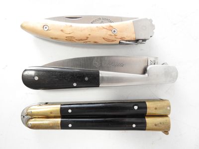 three different types of knives on a white surface