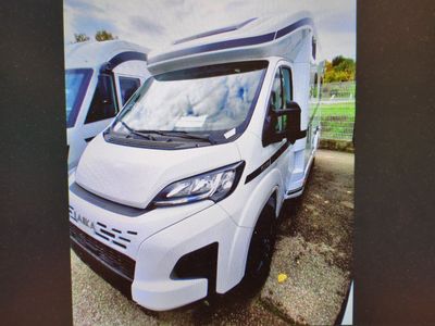 une photo d'un camping-car blanc garé sur un parking