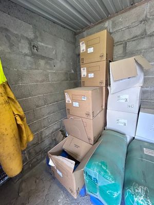 a pile of boxes in a storage room next to a wall