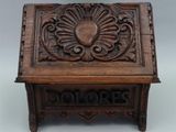 an old wooden box with a carved design on top of it