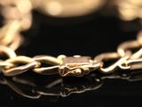 a close up of a gold chain bracelet on a black surface