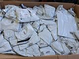 a cardboard box full of white shirts and pants