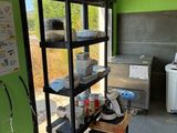 a kitchen with a green wall and a black shelf