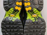 the soles of a pair of black and yellow hiking shoes